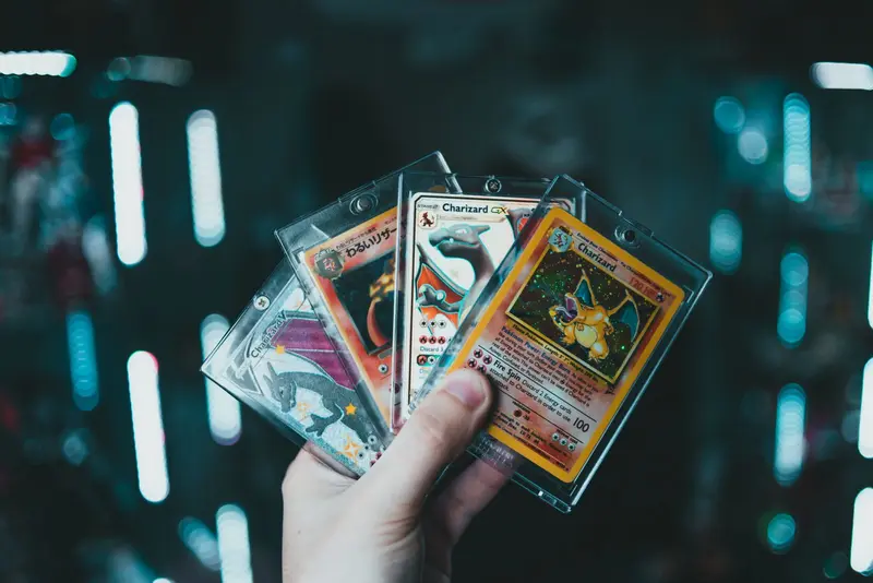 A collector's hand fanning out cards in top loaders and sleeves